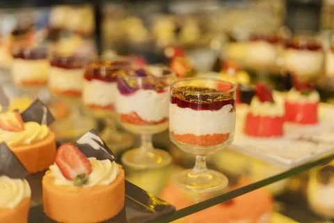 A tempting array of desserts showcases vibrant cakes and creamy layers topped Foto stock