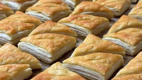A tempting array of golden-brown puff pastries fresh from the oven, showing deli Stock-Footage 330127575
