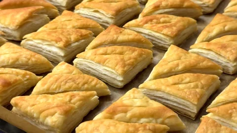 A tempting array of golden-brown puff pastries fresh from the oven, showing deli Stock-Footage 330524120