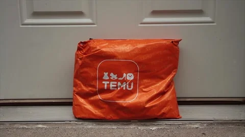Temu orange rectangle bag package with logo on it delivery delivered leaning Vídeo Stock 247754510