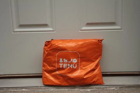 Temu orange rectangle bag package with logo on it delivery delivered leaning Stock Photos