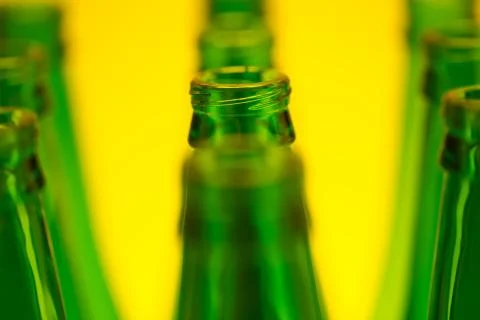 Ten Green Bottles in Three Rows Shot with Yellow Light. Stock Photos