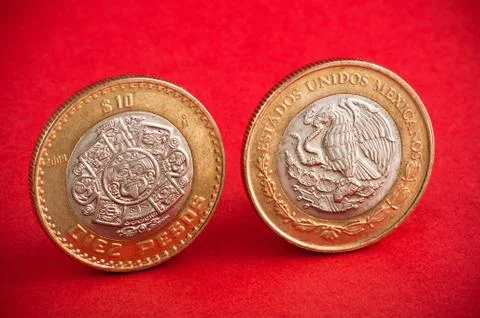 Ten mexican coin on red background. Shot close up Stock Photos