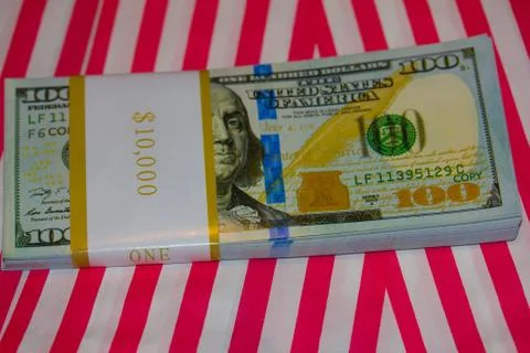 Ten Thousand Dollars Stack in hundreds on Red &amp; White Striped Background Stock Photos