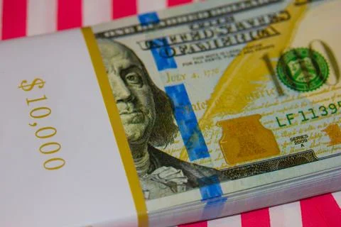 Ten Thousand Dollars Stack in hundreds on Red &amp; White Striped Background Stock Photos