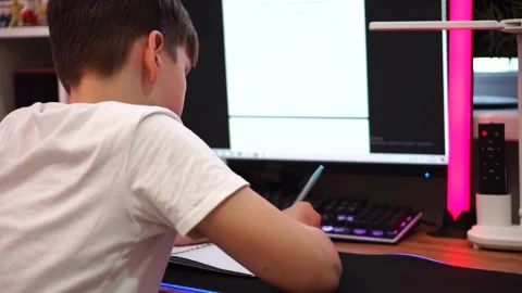 Ten year old boy diligently doing written homework sitting at table. close up 库存影片 307121784