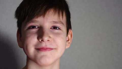 Ten year old boy looking at camera and smiling a little. close-up portrait Stock Footage 297451176