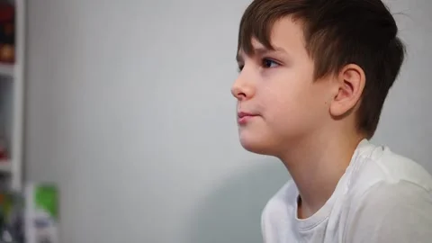 Ten year old boy playing console on TV. Face turned to the side Stock Footage 297553199
