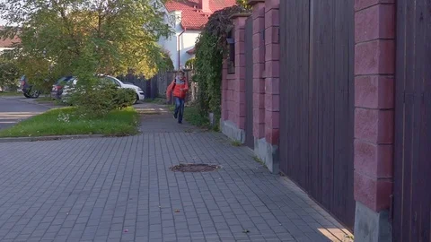 A ten year old student runs to, from the school with a backpack on his back and Stock Footage 89223028