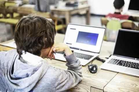 Tenager boy writes codes on a computer at school in a programming lesson. B.. Stock Photos