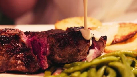 Tender beef steak with vegetables, potatoes and green beans, close-up of a hand Stock-Footage 335807374