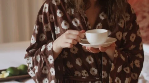 Tender brunette in bathrobe drinks tea Stock Footage 73898938