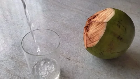 Tender coconut water being poured in a glass. Refreshing natural drink in sum Stock-Footage 181011953