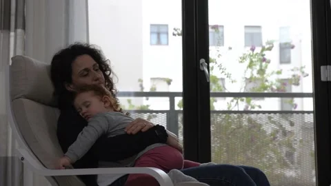 The tender image of a little girl while sleeping in the arms of her mother Stock Footage 130539171