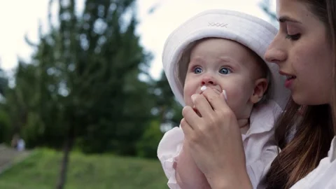 Tender moment between mother and baby outdoors in a park setting Stockbeeldmateriaal 342494853