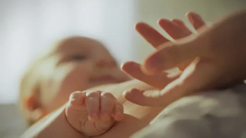 Tender moment between a parent and their baby in soft morning light Stock Footage 295129574