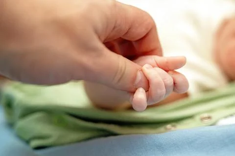 Tender moment captured as a baby's tiny hand hugs the father's thumb, symboli Stock Photos