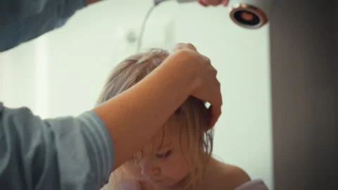 Tender mother gently dries her little ones wet hair with hairdryer at home e Stock Footage 331459449