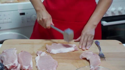 Tenderizing Fresh Pork Meat for a Delicious Homemade Dinner Stock Footage 321825092