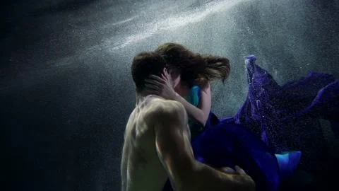 Tenderness and passion of lovers floating underwater, young woman and handsome Vidéo 181796346