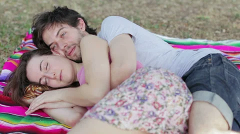 Tenderness, two lovers embraced on the lawn exchange kisses and laugh Stockbeeldmateriaal 28498951