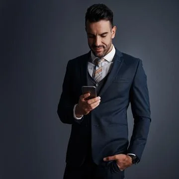Tending to business with smart tech. Studio shot of a stylish young businessman Stock Photos
