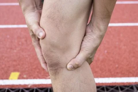 Tendon knee joint problems on Man leg from exercise In the stadium Stock Photos