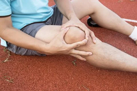 Tendon knee joint problems on Man leg from exercise In the stadium 库存照片