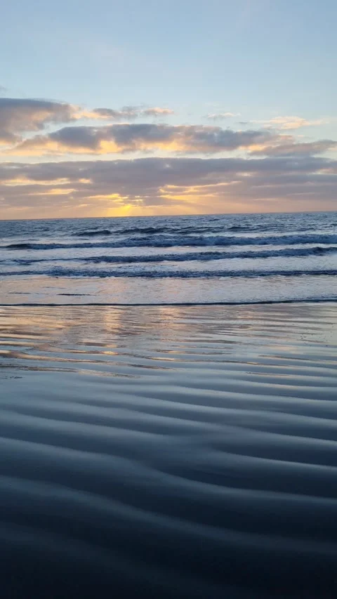 Tenerife's stunning sunset casts its final rays over the ocean, with the waves  Stock Footage 307632695