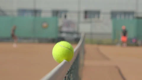 The tennis ball falls on the net cable and rolls onto the court Stock Footage 284560282