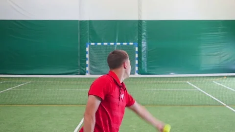 Tennis player jumps up and hits the ball on court Stock Footage