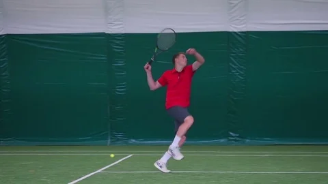 Tennis player pitches a ball during a jump Stock Footage