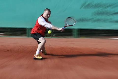 Tennisspieler Tennisspieler schlägt Rückhand Slice auf Sandplatz (License=. Stock Photos