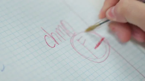 Tense classroom scene with student fixing written work on graph paper. Young Stock Footage 329889197
