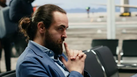 Tense man entrepreneur using AI assistant system on laptop in airport lounge Stock Footage 339644084