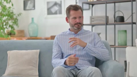 Tense Middle Aged Man Sitting in disbelief at Home Stock Footage 287897679