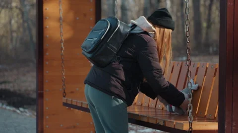Tense toy theft. Quiet winter park setting with woman hiding plush toy. Woman Stock Footage 332042609