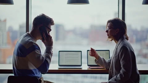 Tensed colleagues calling cellphone at big windows company workplace closeup Stock Footage 335244185