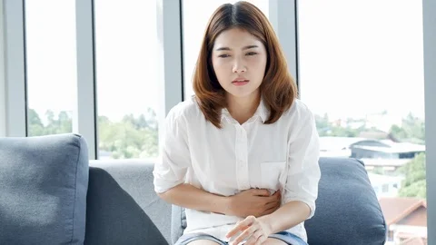 Tension stress asian women have stomachache touching her temples feeling stress  Stock Footage
