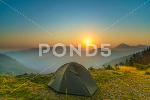 The tent on the background of foggy mountain landscape. Wide angle Stock Photos