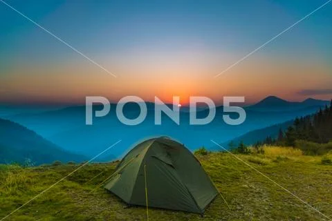 The tent on the background of foggy mountain landscape. Wide angle Stock Photos
