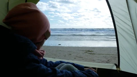Tent on the beach. 4k. view from the tent on the sea. girl sitting in tent and Video stock 82147183