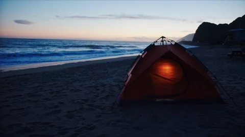 Tent at a beach lighted from inside, camping at coast Stock Footage 127409158