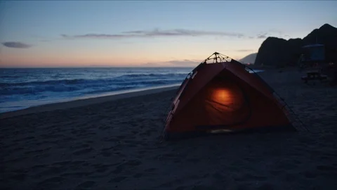 Tent at a beach lighted from inside, camping at coast Vídeos de archivo 127409204