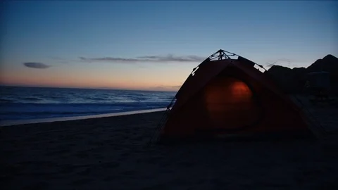 Tent at a beach lighted from inside, camping at coast Stockbeeldmateriaal 127409439
