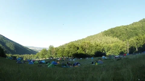 Tent camp in a mountain forest at sunset, green grass Stock Footage 44746530