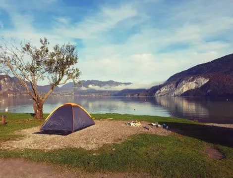 Tent by a lake with mountains behind. Stock Photos