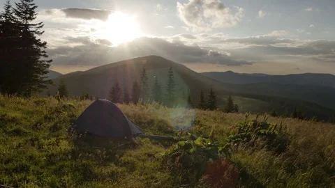 Tent is in the mountains at sunset. wind shakes the grass Stock Footage 77566468