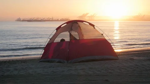 Tent by the Pacific ocean coast at sunset Stock Footage