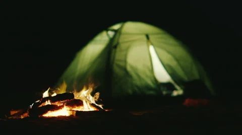 The tent in which the light shines near the fire burning. Romance and relaxation Stock Footage